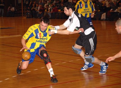 Domácí rozehrávač Daniel Prepsl se snaží dostat přes vysunutou obranu Karviné. V odvetě čtvrtfinále extraligy házené Kopřivnice doma utrpěla debakl.<br/>                                 
FOTO: DAVID MACHÁČEK
