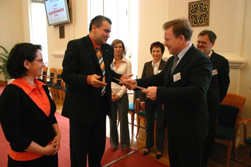 Starosta přebírá z rukou Romana Hakena, ředitele českého Centra pro komunitní práci, ocenění v mezinárodní soutěži O lidech s lidmi.<br/>                                                                        
FOTO: JIŘÍ PAVLÁT
