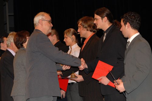 Čerství absolventi vyšší odborné školy přebírají drobný dárek a gratulace k absolutoriu od místostarosty Zdeňka Krajčíra.<br/>                   
FOTO: DAVID MACHÁČEK
