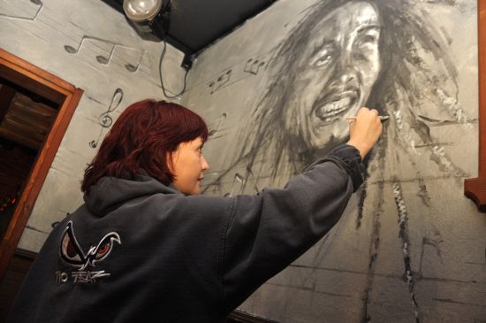 Anička Schwarzová dokončuje práce na portrétu Boba Marleyo, který je součástí její zatím největší realizace v jednom z místních zábavních podniků.
FOTO: DAVID MACHÁČEK
