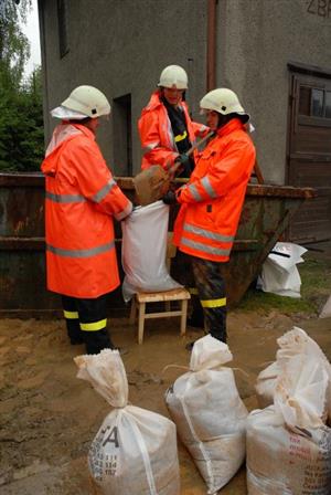 Vlčovičtí dobrovolní hasiči plní pytle pískem. Provizorní protipovodňové zábrany mnohde zabránily tomu, aby rozvodněná Lubina napáchala ještě více škod. 
FOTO: DAVID MACHÁČEK