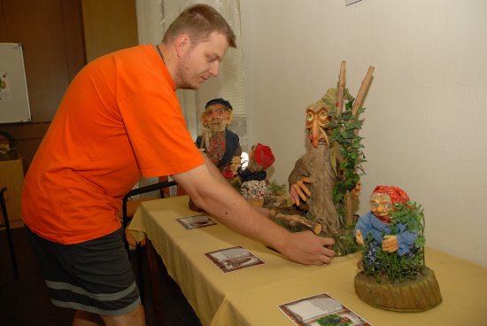 Pracovník městské knihovny Pavel Šenk při instalaci jedné z loutek prázdninové výstavy nazvané Potulná pohádková země. Ta bude k vidění v čítárně do konce prázdnin. 
FOTO: DAVID MACHÁČEK