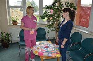 Knihovnice Hana Žárská předala 12. dubna Monice Kupkové, staniční sestře perinatologického oddělení FN v Ostravě, oblečky pro miminka. 
FOTO: PAVEL ŠENK
