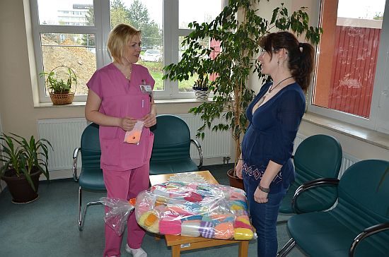 Knihovnice Hana Žárská předala 12. dubna Monice Kupkové, staniční sestře perinatologického oddělení FN v Ostravě, oblečky pro miminka. 
FOTO: PAVEL ŠENK
