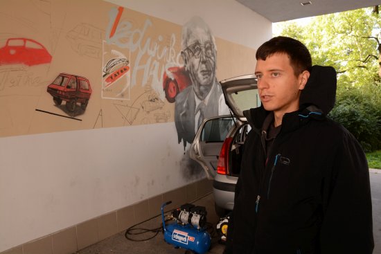 Hynek Tekula v pauze při práci na velkoprostorové malbě v průchodu pod zdejší radnicí. Mladý umělec jí složil hold tatrováckému konstruktérovi Hansi Ledwinkovi.
FOTO: D. MACHÁČEK