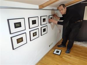 Ondřej Přibyl při instalaci fotogramů z cyklu Jednotliviny, které jsou součástí právě probíhající výstavy v prostorách Lašského muzea. 
FOTO: DAVID MACHÁČEK