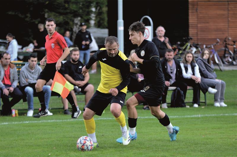 Fotbalisté Vlčovic-Mniší (ve světlejším dresu Roman Vrba) po dvoutýdenní pauze předvedli dobrý výkon a favorizovaný Příbor pořádně potrápili. FOTO: DAVID MACHÁČEK