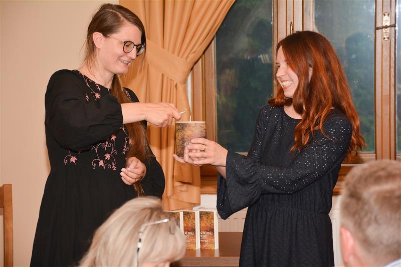 Klára Machů zapaluje svíčku, kterou symbolicky pokřtila svou debutovou básnickou sbírku. Kmotrou a redaktorkou knihy byla Tereza Šustková